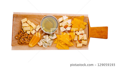 Cheese and snack platter displayed on wooden board with nuts and citrus 129059193
