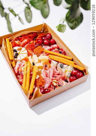 Delicious charcuterie board featuring meats, cheeses, fruits, and snacks 129059216