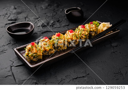 Sushi platter with colorful toppings served on a dark stone background 129059253