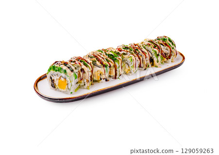 Delicious sushi roll served on a white plate with garnishes and sauces 129059263