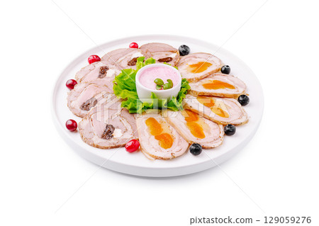 Gourmet platter of sliced meat and sauces displayed on a white serving dish 129059276