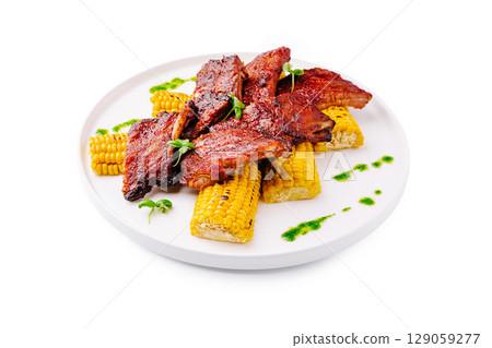 Grilled ribs served with sweet corn and green sauce for a summer meal 129059277