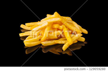 Golden crispy French fries served with a shiny reflection on a black background 129059280