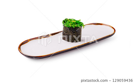 Sushi roll with seaweed and greenery on a minimalist plate Sushi roll with seaweed and greenery on a minimalist plate 129059436