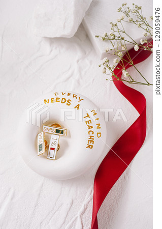 Decorative donut with educational pins and ribbon on a white background 129059476
