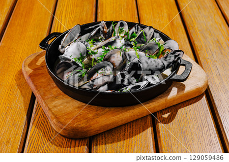 Delicious fresh seafood dish served in a skillet on wooden table 129059486