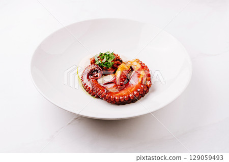 Octopus dish presented beautifully on a white plate with garnish Octopus dish presented beautifully on a white plate with garnish 129059493