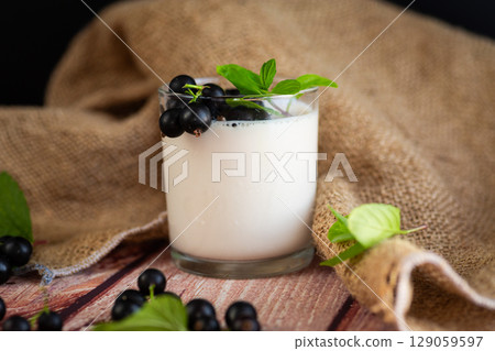Natural yogurt with blackcurrant on a wooden 129059597