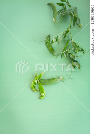 Macro photography of fresh peas and greenery in pods 129059605