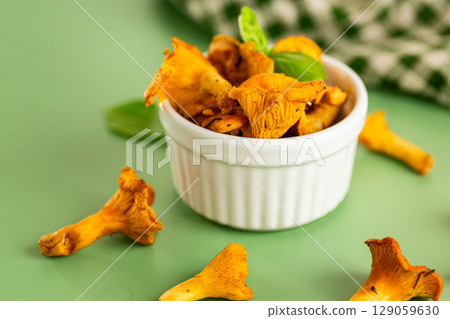 Forest chanterelle mushrooms on a green background 129059630