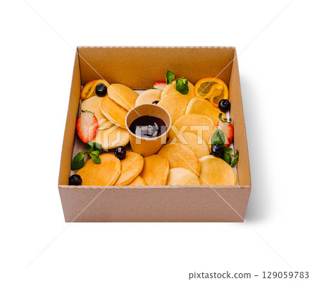 Delicious pancakes served in a box with fresh fruits and syrup Delicious pancakes served in a box with fresh fruits and syrup 129059783