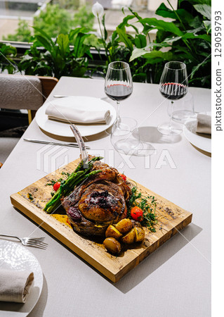 Deliciously plated rack of lamb served with vegetables and wine 129059793