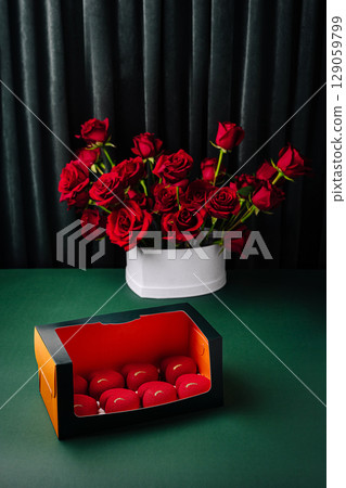 Elegant arrangement of red roses and decorative box on green table Elegant arrangement of red roses and decorative box on green table 129059799