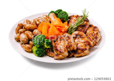 Grilled chicken with vegetables and roasted potatoes on a white plate 129059801