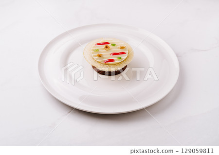 Unique dessert creation with colorful toppings on a white plate 129059811