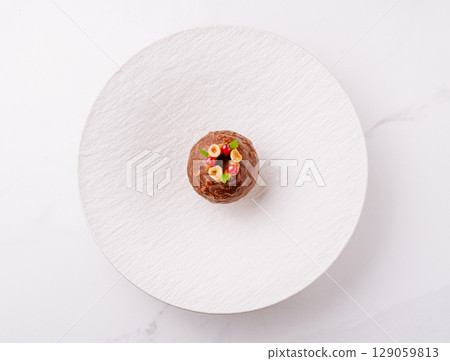 Dessert creation on a minimalistic white plate at a modern restaurant setting Dessert creation on a minimalistic white plate at a modern restaurant setting 129059813