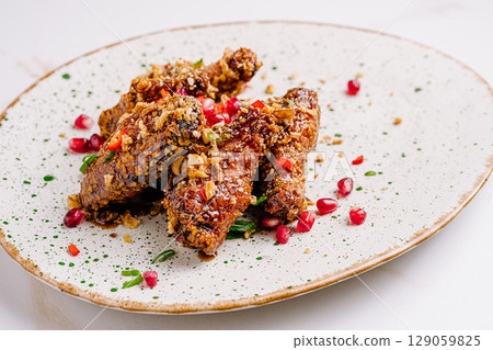 Delicious crispy chicken wings with pomegranate and herbs Delicious crispy chicken wings with pomegranate and herbs 129059825