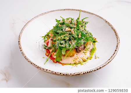 Delightful salad with vibrant greens and colorful toppings served elegantly Delightful salad with vibrant greens and colorful toppings served elegantly 129059830