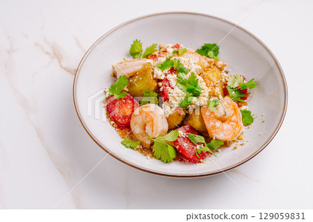 Delicious shrimp dish with fresh vegetables and herbs served in a bowl 129059831