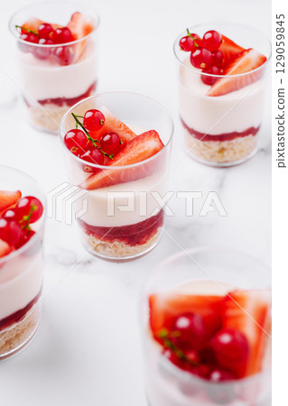 Delicious dessert cups with fresh fruit on a marble background 129059845