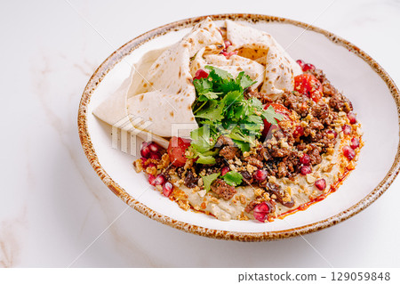 Delicious dish featuring seasoned meat, fresh ingredients, and herbs Delicious dish featuring seasoned meat, fresh ingredients, and herbs 129059848