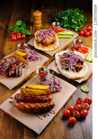 Delicious grilled meats served with fresh vegetables and vibrant sauces Delicious grilled meats served with fresh vegetables and vibrant sauces 129059884