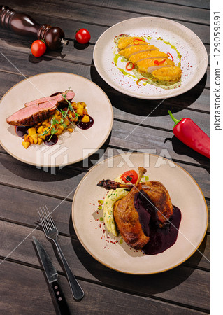 Elegant gourmet dishes served on stylish plates at a restaurant table setting Elegant gourmet dishes served on stylish plates at a restaurant table setting 129059891