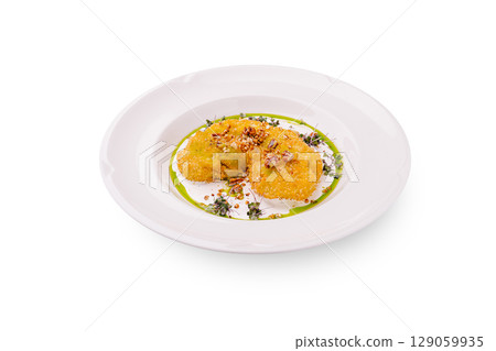 Crispy golden fritters served on a plate with fresh herbs and sauce Crispy golden fritters served on a plate with fresh herbs and sauce 129059935