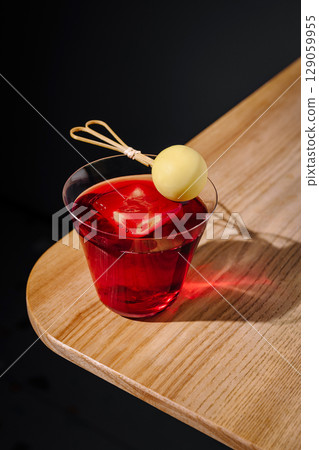 Creative cocktail served in a clear glass with a yellow garnish Creative cocktail served in a clear glass with a yellow garnish 129059955