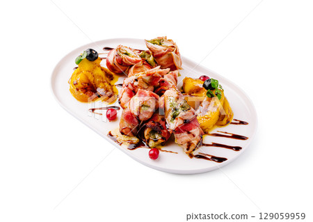 Gourmet rolled meat with fruit garnishes on a white platter Gourmet rolled meat with fruit garnishes on a white platter 129059959