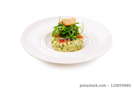 Fresh vegetable tartare with arugula and crispy garnish served on a white plate Fresh vegetable tartare with arugula and crispy garnish served on a white plate 129059960