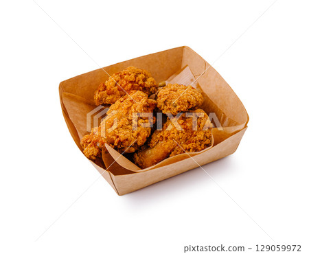 Crispy fried chicken wings served in a brown paper container Crispy fried chicken wings served in a brown paper container 129059972