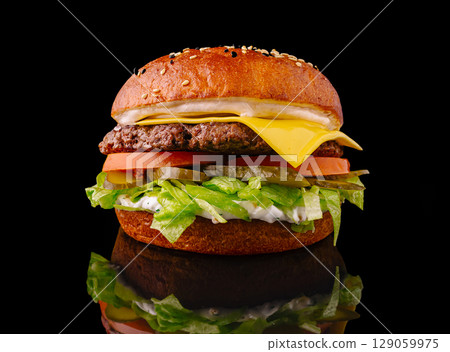 Delicious cheeseburger with fresh ingredients on a black background 129059975