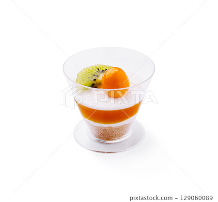Delicious dessert with layers of fruit and cream in a stylish glass cup Delicious dessert with layers of fruit and cream in a stylish glass cup 129060089