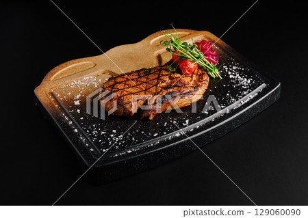 Grilled steak served on a unique platter with fresh herbs Grilled steak served on a unique platter with fresh herbs 129060090