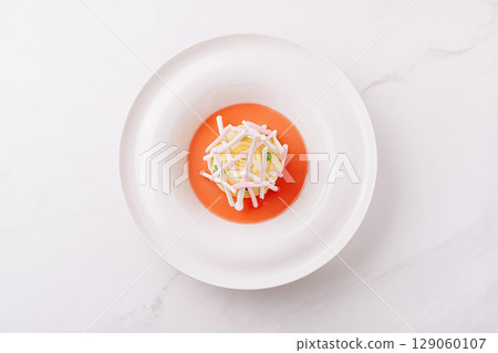 A meticulously arranged dessert sits on a pristine white plate 129060107
