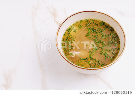 Warm homemade broth with herbs and tender meat for a comforting meal 129060119