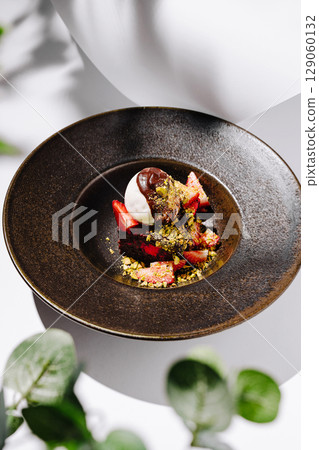 Decadent dessert featuring strawberries and chocolate served in elegant dish Decadent dessert featuring strawberries and chocolate served in elegant dish 129060132