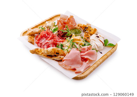 Savory charcuterie platter featuring meats and cheeses arranged on a wooden tray Savory charcuterie platter featuring meats and cheeses arranged on a wooden tray 129060149