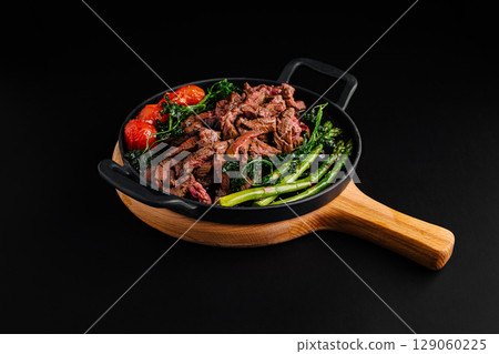 Savory beef stir-fry with fresh vegetables on a wooden platter Savory beef stir-fry with fresh vegetables on a wooden platter 129060225