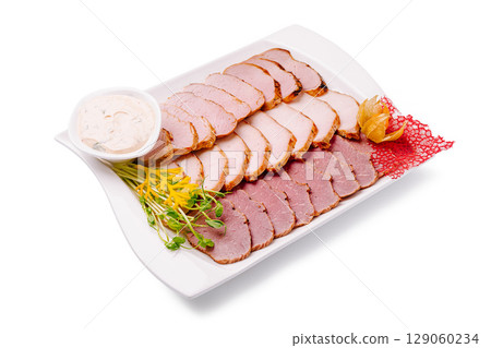 Deliciously arranged cold cuts with sauce and garnishes on a platter 129060234