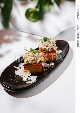 Unique culinary creation featuring layered savory dish on elegant plate 129060260