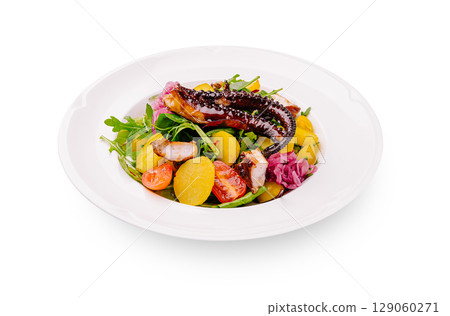 Octopus salad with vegetables served on a white plate at a restaurant 129060271