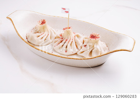 Unique presentation of dumplings with decorative flags and seasoning 129060283