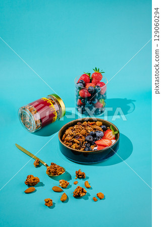 Healthy breakfast bowl with berries and granola on bright blue background Healthy breakfast bowl with berries and granola on bright blue background 129060294