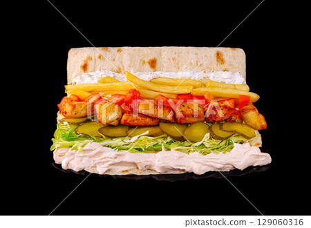 Delicious wrap filled with grilled chicken, fresh vegetables, and sauces Delicious wrap filled with grilled chicken, fresh vegetables, and sauces 129060316