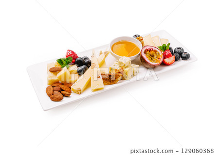 Cheese and fruit platter with honey on white serving dish Cheese and fruit platter with honey on white serving dish 129060368