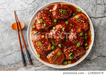 Sweet and sour pork chops are delicious and covered in a glaze made out of brown sugar, soy sauce, hoisin and Worcestershire sauce closeup on the plate. Horizontal top view Sweet and sour pork chops are delicious and covered in a glaze made out of brown sugar, soy sauce, hoisin and Worcestershire sauce closeup on the plate. Horizontal top view 129060479
