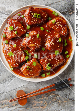 Asian style sweet and sour pork chops close-up in a plate. Vertical top view 129060481
