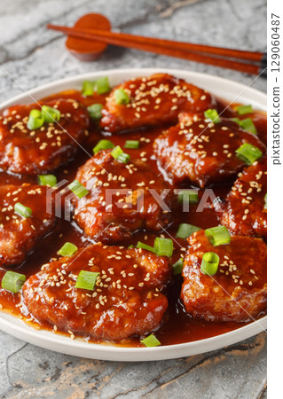 Asian style sweet and sour pork chops close-up in a plate. Vertical Asian style sweet and sour pork chops close-up in a plate. Vertical 129060487